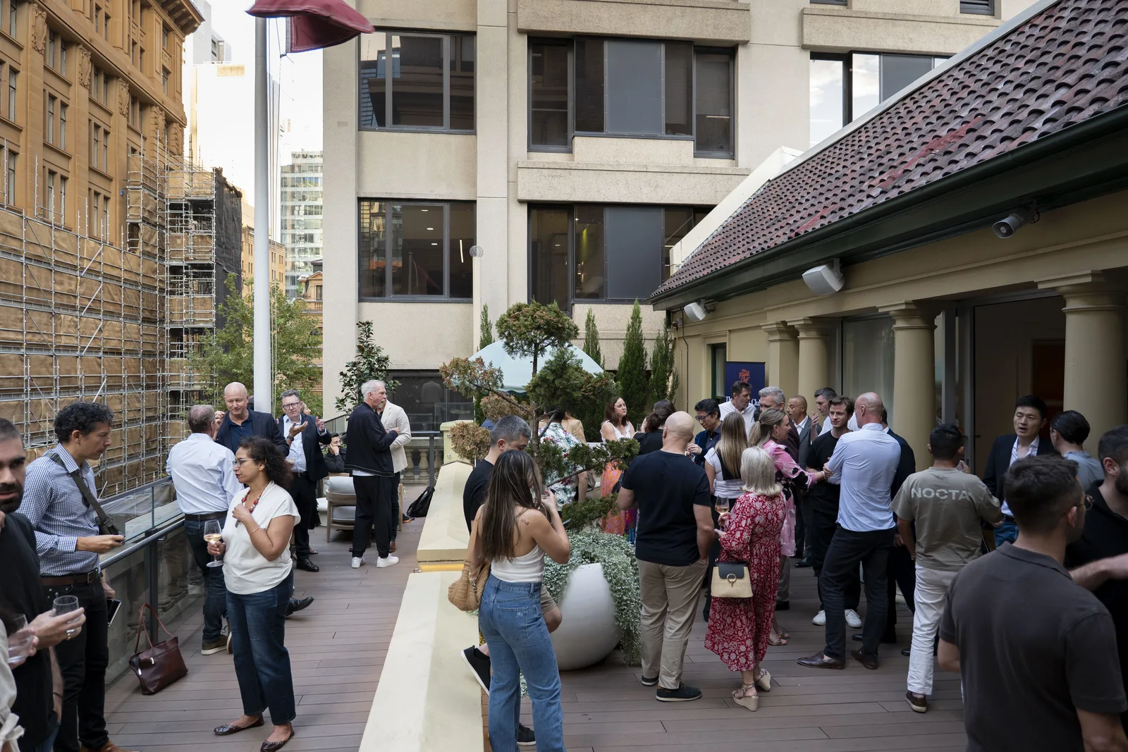 Sydney Rooftop Mingle — Flights Club members networking on a CBD terrace with heritage Sydney buildings in the background.