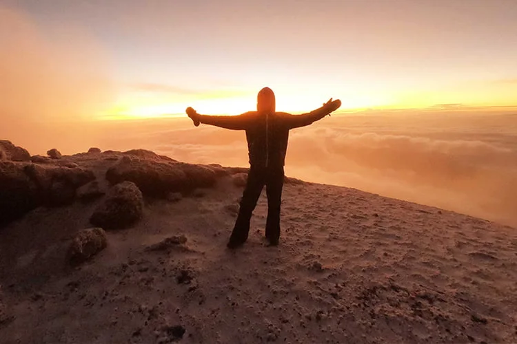 A climber silhouetted at sunrise on Kilimanjaro