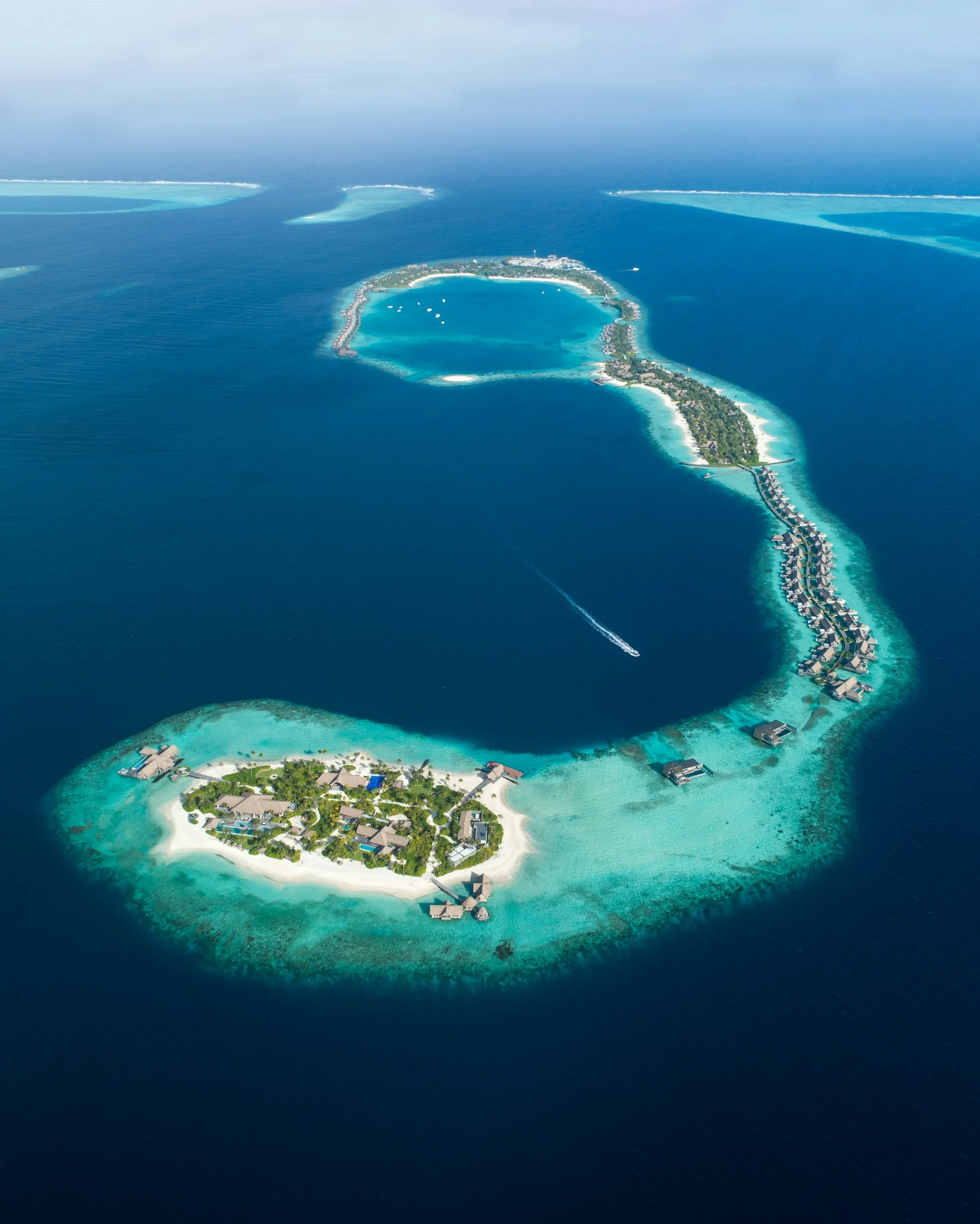An island and overwater villas surrounded by turquoise lagoons in the Maldives
